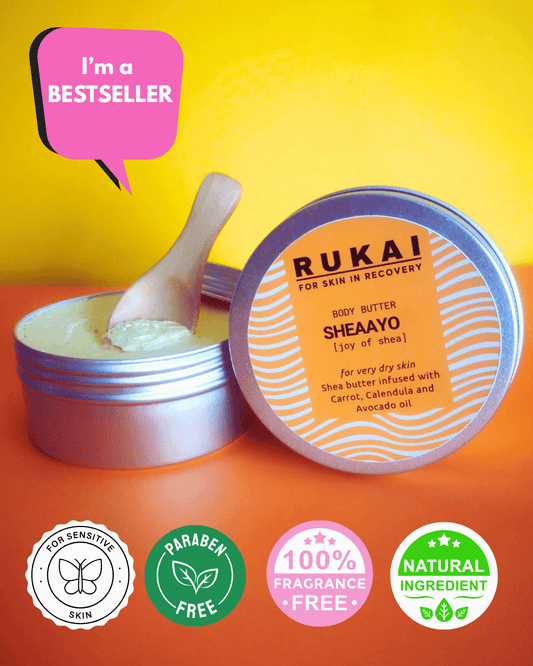 Rukai Sheaayo body butter for eczema, recyclable container with a scoop on a colourful background